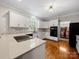 Modern kitchen featuring white cabinets, black appliances, hardwood floors, and an island with seating at 8527 Foxbridge Dr, Matthews, NC 28104