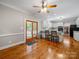 Bright, open kitchen featuring white cabinets, hardwood floors, a ceiling fan, and a view to the backyard at 8527 Foxbridge Dr, Matthews, NC 28104