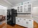 Kitchen showcasing white cabinets, black appliances, hardwood floors, and access to the dining area at 8527 Foxbridge Dr, Matthews, NC 28104