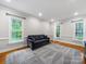 Cozy living room with a gray sofa, hardwood floors, and natural light from the windows at 8527 Foxbridge Dr, Matthews, NC 28104