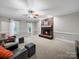 Comfortable living room with a brick fireplace, plush seating, and natural light from windows at 8527 Foxbridge Dr, Matthews, NC 28104