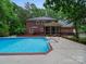 Beautiful brick home featuring a refreshing in-ground pool and manicured landscaping at 8527 Foxbridge Dr, Matthews, NC 28104