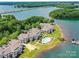 Expansive aerial view of waterfront condos with a pool, boat docks, and serene lake scenery at 930 Jetton St, Davidson, NC 28036