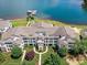 Aerial view of an apartment complex on the lake with lush lawns, colorful trees, and a private dock at 930 Jetton St, Davidson, NC 28036