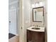 Well-lit bathroom featuring a copper sink with dark wood cabinets and a mirror with decorative lighting at 930 Jetton St, Davidson, NC 28036