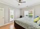 Comfortable bedroom features a ceiling fan, multiple windows, and attractive decor with wood floors at 930 Jetton St, Davidson, NC 28036