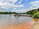 Lakeside view with a dock featuring several boats, surrounded by lush trees and blue skies at 930 Jetton St, Davidson, NC 28036