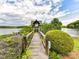 Scenic wooden walkway leading to a gazebo overlooking a calm lake surrounded by lush greenery and blue skies at 930 Jetton St, Davidson, NC 28036