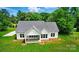 Aerial view of charming home featuring a covered patio, lush green lawn, and a classic gray roof at 9311 Simpson Rd, Waxhaw, NC 28173