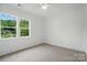 Sun-filled bedroom featuring neutral carpet and a view of the landscaped yard at 9311 Simpson Rd, Waxhaw, NC 28173