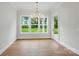 The dining room features hardwood floors, a chandelier, and three large windows overlooking the lawn at 9311 Simpson Rd, Waxhaw, NC 28173
