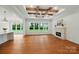 Bright and airy living room featuring hardwood floors, a brick fireplace, and a beamed ceiling at 9311 Simpson Rd, Waxhaw, NC 28173