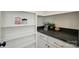 Butler's pantry features stone countertops, white cabinets and shelving with glass jars at 9311 Simpson Rd, Waxhaw, NC 28173