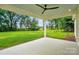Covered patio with fan offers serene views of the expansive backyard and lush green landscape at 9311 Simpson Rd, Waxhaw, NC 28173