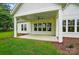 Covered patio with brick border, ceiling fan, and multiple windows offering views of the surrounding landscape at 9311 Simpson Rd, Waxhaw, NC 28173