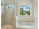Bright bathroom featuring a soaking tub, glass-enclosed shower, and natural light at 9315 Simpson Rd, Waxhaw, NC 28173