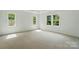Spacious bedroom with plush carpeting, three windows, and natural light at 9315 Simpson Rd, Waxhaw, NC 28173