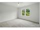 This bedroom features neutral carpet, a ceiling fan, and a window with natural light at 9315 Simpson Rd, Waxhaw, NC 28173