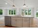 Gorgeous kitchen island featuring a built-in dishwasher, a faucet and sink and pendant lighting at 9315 Simpson Rd, Waxhaw, NC 28173