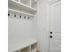 Bright mudroom area featuring white shelving, coat hooks, and a bench near the entry at 9315 Simpson Rd, Waxhaw, NC 28173