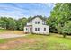 An attractive two-story white farmhouse with black trim and lush green lawn at 1011 Sandy Ct, Gastonia, NC 28056