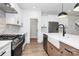 Modern kitchen featuring stainless steel appliances, white cabinetry, and a farmhouse sink at 1011 Sandy Ct, Gastonia, NC 28056