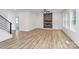 Open-concept living space with fireplace, hardwood floors, recessed lighting, and access to stairs at 1011 Sandy Ct, Gastonia, NC 28056