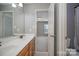 Bathroom featuring double sinks, wood cabinets, and neutral paint with an opening to a bedroom at 10515 Greenhead View Rd, Charlotte, NC 28262