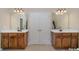 Bathroom with double sinks, wood cabinets, and large mirrors at 10515 Greenhead View Rd, Charlotte, NC 28262