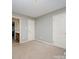Neutral bedroom with a view to en suite bathroom and closet with doors at 10515 Greenhead View Rd, Charlotte, NC 28262