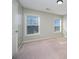 Bright, carpeted bedroom featuring two windows providing ample natural light at 10515 Greenhead View Rd, Charlotte, NC 28262