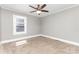 Neutral bedroom featuring a ceiling fan, plush carpet, and a window for natural light at 1103 Oklahoma St, Kannapolis, NC 28083