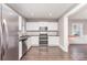 Updated kitchen with stainless steel refrigerator, white cabinets, dark countertops, microwave and stove at 1103 Oklahoma St, Kannapolis, NC 28083