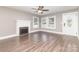 Cozy living room featuring hardwood floors, fireplace, bright windows, and decorative trim at 1103 Oklahoma St, Kannapolis, NC 28083