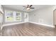 Bright living room with hardwood floors, ceiling fan, and large windows offering plenty of natural light at 1103 Oklahoma St, Kannapolis, NC 28083