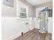 Utility room with water heater, wood-look floor, and wainscotting at 1103 Oklahoma St, Kannapolis, NC 28083