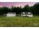 Charming home with detached garage on a lush green lawn and trees in the background at 1135 Brook Path Trl, Denver, NC 28037