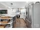 Open floor plan showcasing kitchen with island, stainless steel appliances, and hardwood floors at 1135 Brook Path Trl, Denver, NC 28037