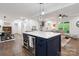 Open floor plan showcasing kitchen island, dining area, and living room with hardwood floors at 1135 Brook Path Trl, Denver, NC 28037