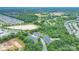 Aerial view of homes at 11945 Red Rust Lane, surrounded by verdant trees, a pond, and adjacent community at 11945 Red Rust Ln, Charlotte, NC 28277