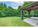 Lush backyard with a covered patio featuring stylish curtains, offering a cozy and private outdoor space at 11945 Red Rust Ln, Charlotte, NC 28277
