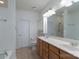Bathroom featuring double sinks, wood cabinets, and large mirror at 11945 Red Rust Ln, Charlotte, NC 28277
