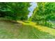 Lush backyard featuring manicured lawn, mature trees, and a fenced perimeter at 12107 Grey Partridge Dr, Charlotte, NC 28278