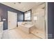 Bathroom with soaking tub, and glass enclosed shower featuring white marble tiling at 12107 Grey Partridge Dr, Charlotte, NC 28278