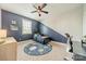 Modern bedroom with blue accent wall, ceiling fan, window and themed rug at 12107 Grey Partridge Dr, Charlotte, NC 28278
