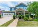 Attractive two-story blue home with a covered porch, manicured landscaping, and a two-car garage at 12107 Grey Partridge Dr, Charlotte, NC 28278