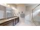 Bathroom with double sinks, granite countertops, tiled floors, and a glass-enclosed shower at 123 Hanks Bluff Dr, Mooresville, NC 28117