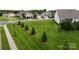Well-manicured front yard featuring green lawn, trimmed trees, and sidewalk in a suburban neighborhood at 123 Hanks Bluff Dr, Mooresville, NC 28117