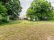 Open backyard with fencing, featuring a brick ranch-style house with a detached garage or shed at 1325 Marshville Olive Branch Rd, Marshville, NC 28103