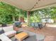 Relaxing covered patio with seating, a grill, and views of the surrounding yard and wooded area at 1325 Marshville Olive Branch Rd, Marshville, NC 28103